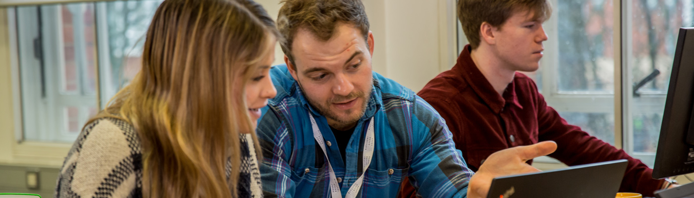 Male and female students in discussion over the contents of a computer screen